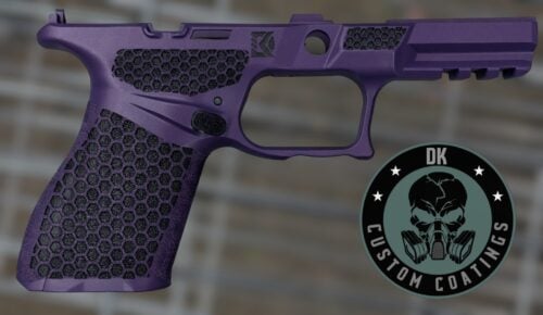 Close-up of a purple handgun grip with hexagonal texture and a circular badge in the corner.