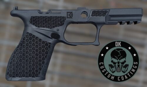 Close-up of a dark gray handgun showing the grip, trigger guard, and slid e with hex-textured panels and a circular logo overlay.