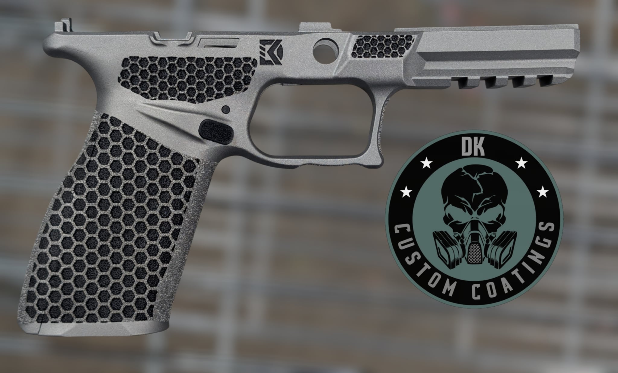 11173 - DK Custom Coatings LLC Close-up of a gray handgun slide and textured grip with a hexagonal honeycomb pattern and a circular logo badge overlapping the right side.