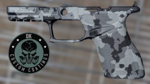 Camouflaged semi-automatic pistol with a circular logo showing a skull wearing a gas mask.