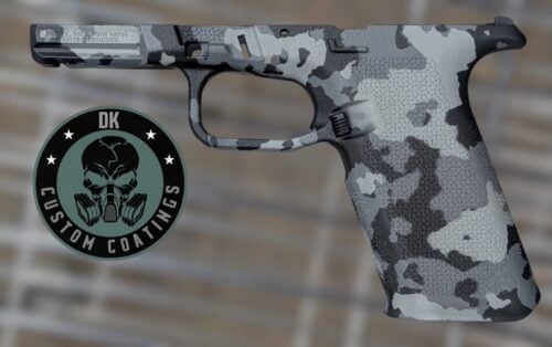Side view of a camouflaged handgun with a circular 'DK Guns Coating' logo in the lower left corner.