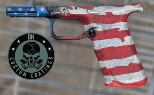 Handgun painted with an American flag finish (Stars and Stripes) shown in close view beside a circular emblem with a skull and gas mask design on the left.